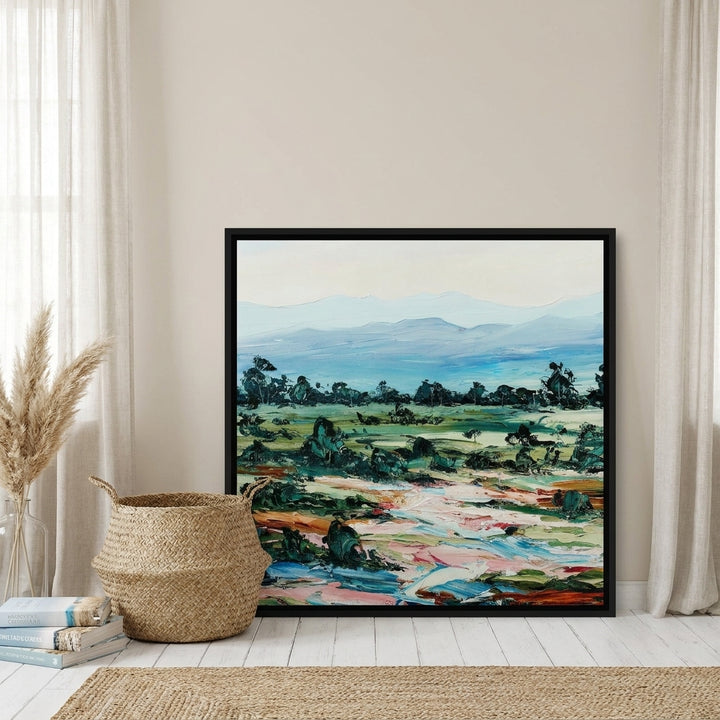 Canvas wall art with a black surround leaning against the wall in a coastal home office