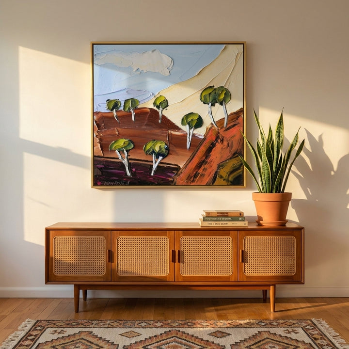 Canvas wall art with a gold leaf surround styled on the wall in a mid-century living room
