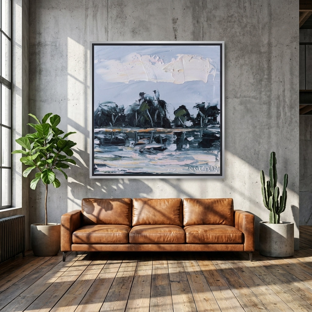 Oversized statement canvas wall art with a silver leaf surround styled on the wall in an industrial loft living room