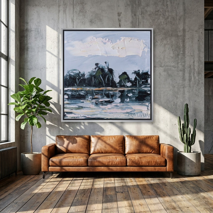 Oversized statement canvas wall art with a silver leaf surround styled on the wall in an industrial loft living room