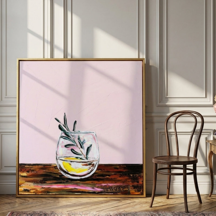Oversized statement canvas wall art with a gold leaf surround leaning against the wall in a Parisian dining room