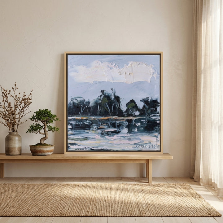 Canvas wall art with a natural timber surround standing on a bench in a warm Japandi bedroom