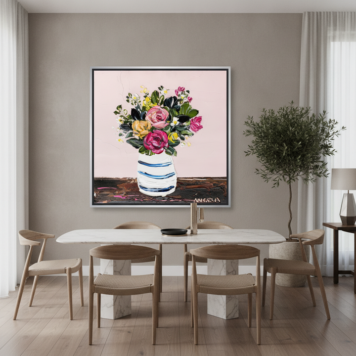Oversized statement canvas wall art with a silver leaf surround styled on the wall in a luxe dining room