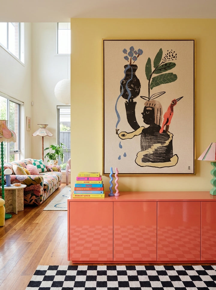 Oversized statement canvas wall art with a gold leaf surround styled on the wall in a colourful eclectic living room