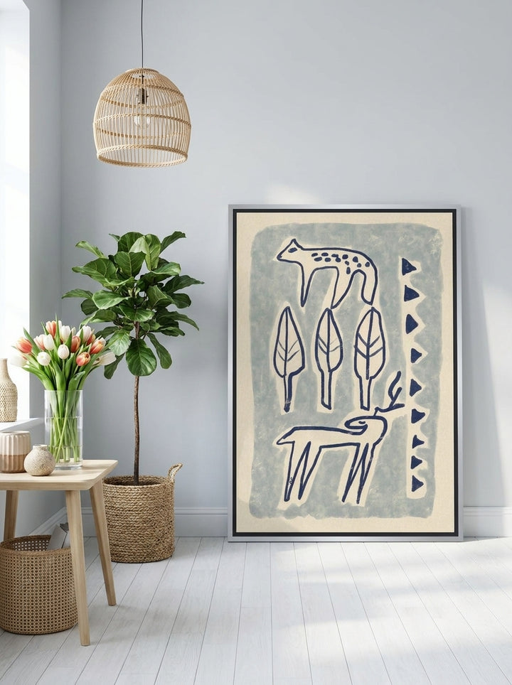 Canvas wall art with a silver leaf surround leaning against the wall in a bright Scandinavian home office