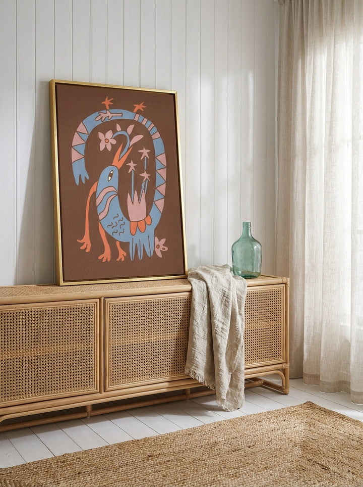 Canvas wall art with a gold leaf surround standing on a sideboard in a coastal bedroom