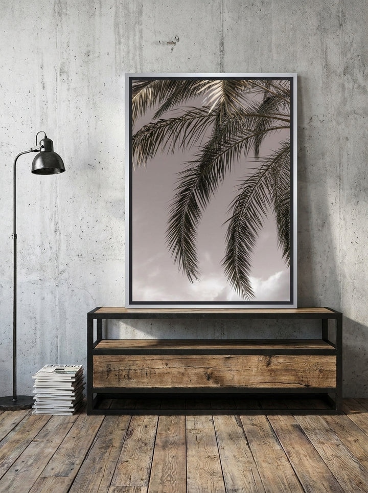 Canvas wall art with a silver leaf surround standing on a console in an industrial loft bedroom