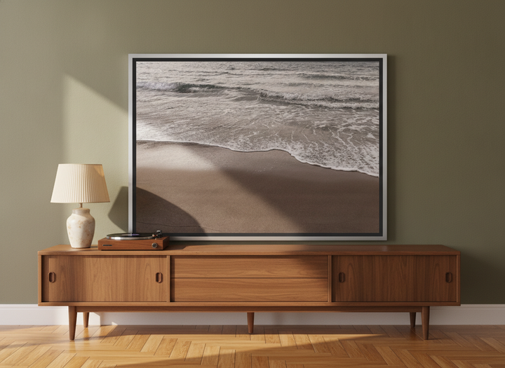 Canvas wall art with a silver leaf surround standing on a sideboard in a mid-century bedroom
