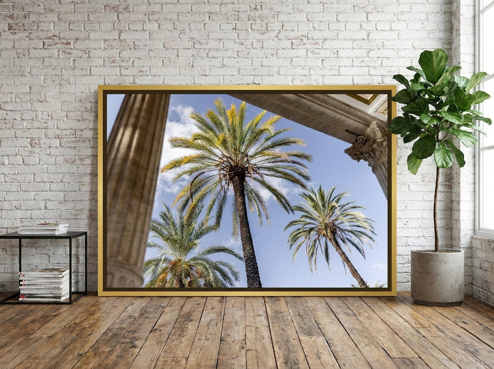 Oversized statement canvas wall art with a gold leaf surround leaning against the wall in an industrial loft living room