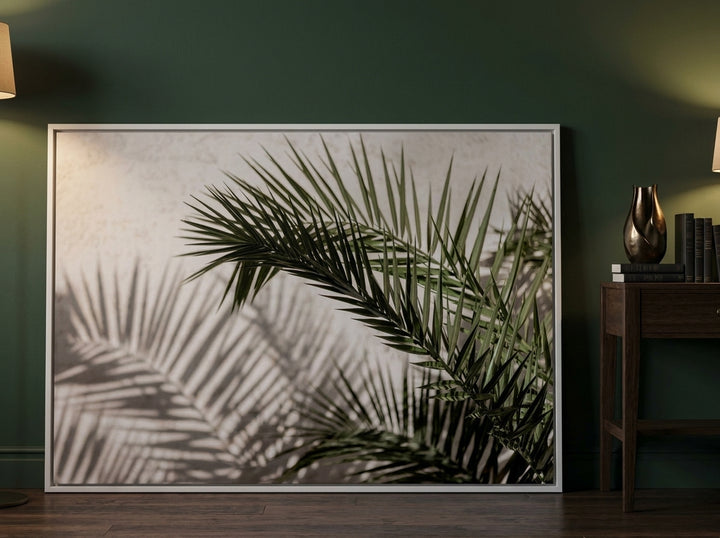 Oversized statement canvas wall art with a white surround leaning against the wall in a moody dining room