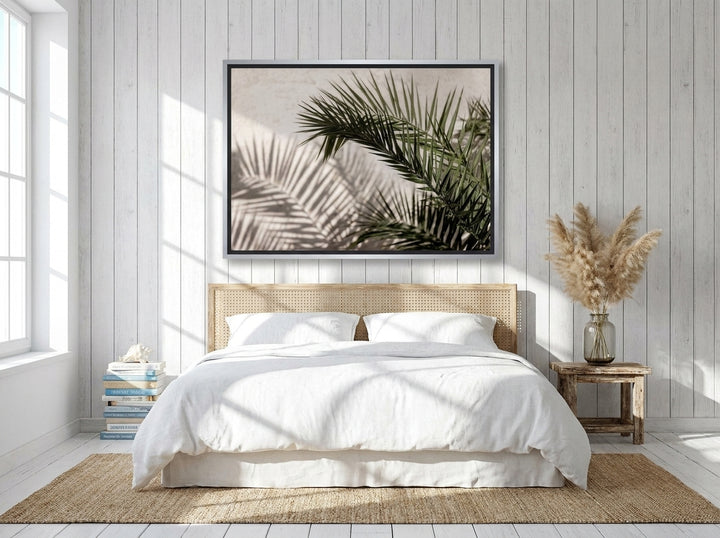 Canvas wall art with a silver leaf surround styled on the wall in a coastal bedroom