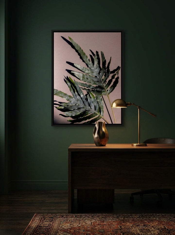 Canvas wall art with a black surround styled on the wall in a moody home office