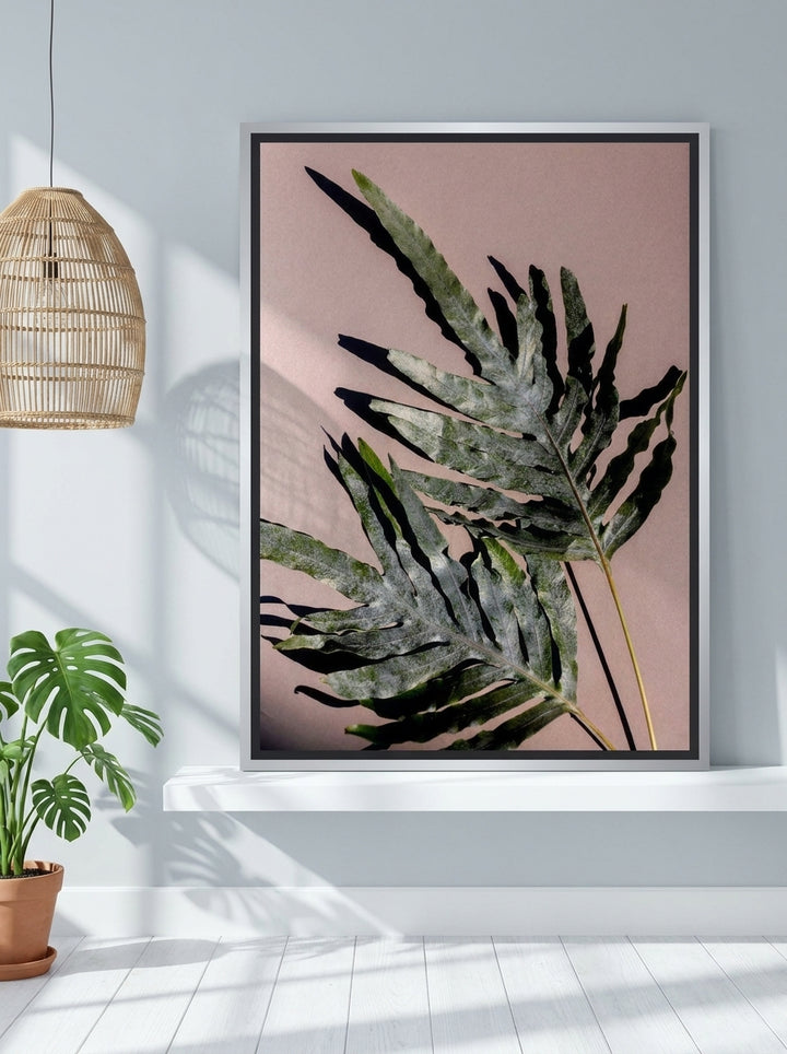 Canvas wall art with a silver leaf surround standing on a shelf in a bright Scandinavian bedroom
