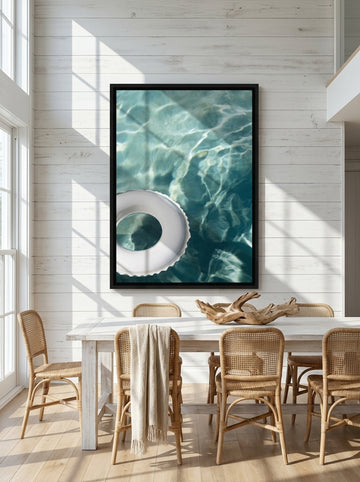 Oversized statement canvas wall art with a black surround styled on the wall in a coastal dining room