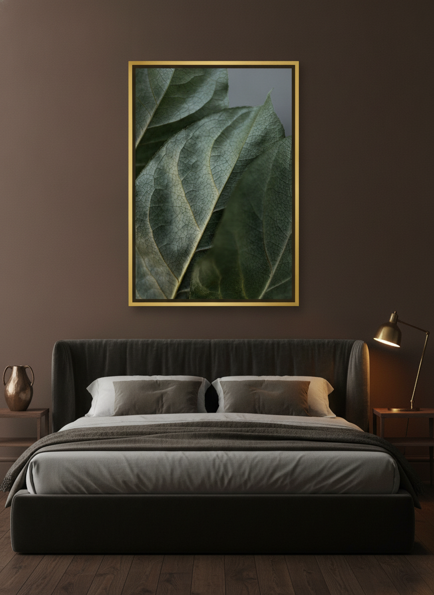 Canvas wall art with a gold leaf surround styled on the wall in a moody bedroom