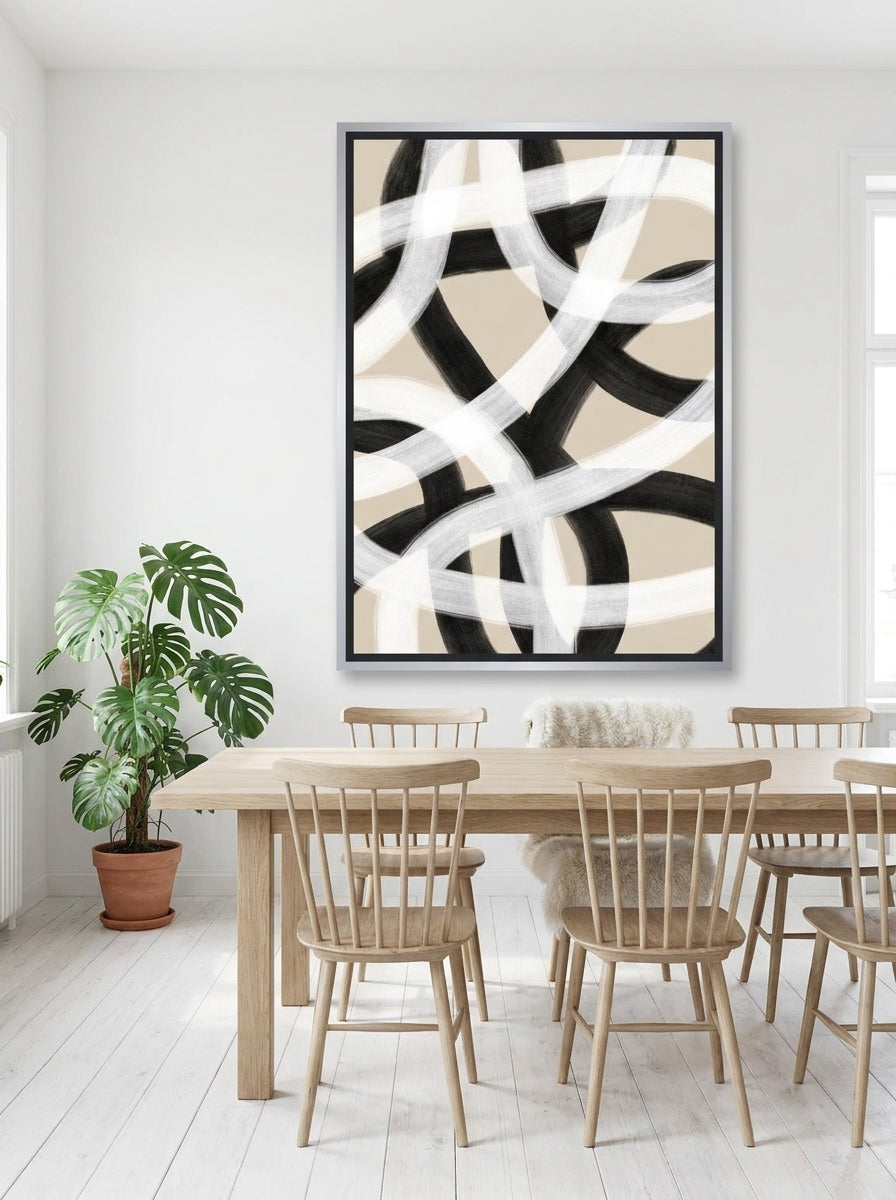 Oversized statement canvas wall art with a silver leaf surround styled on the wall in a bright Scandinavian dining room