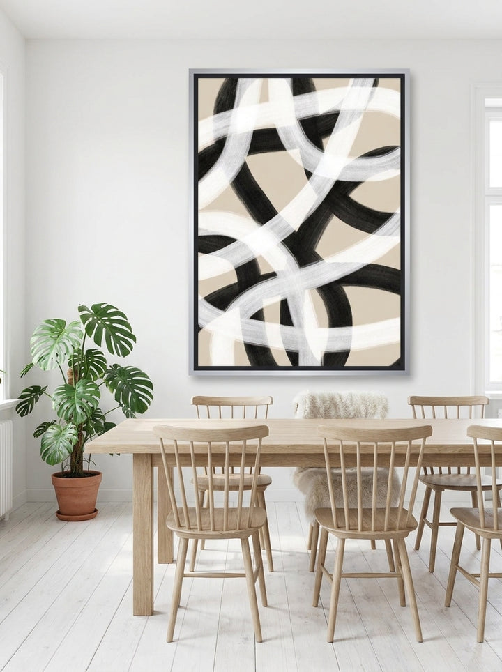 Oversized statement canvas wall art with a silver leaf surround styled on the wall in a bright Scandinavian dining room