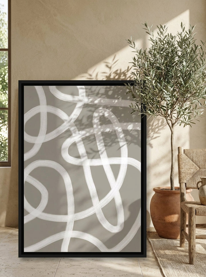 Canvas wall art with a black surround leaning against the wall in a Mediterranean living room