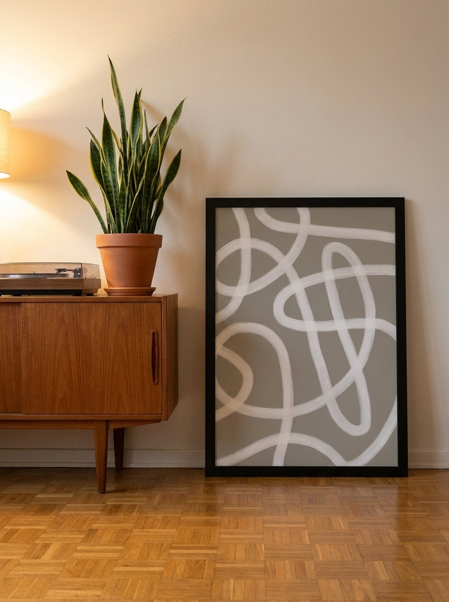 Modern wall art print leaning against the wall in a mid-century living room