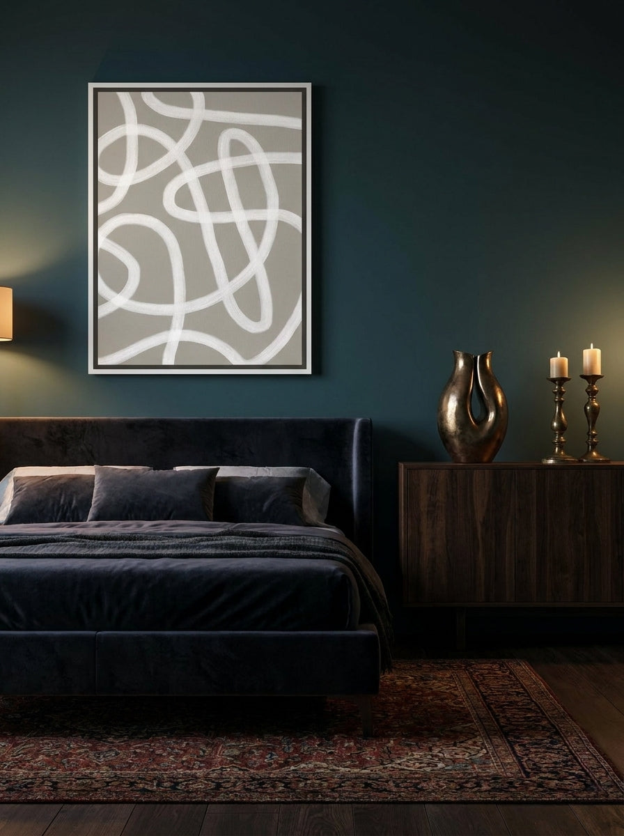 Canvas wall art with a white surround styled on the wall in a moody bedroom