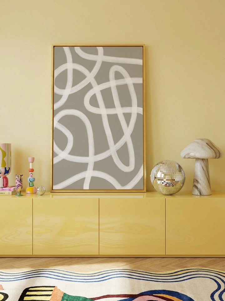Canvas wall art with a gold leaf surround standing on a sideboard in a colourful eclectic home office