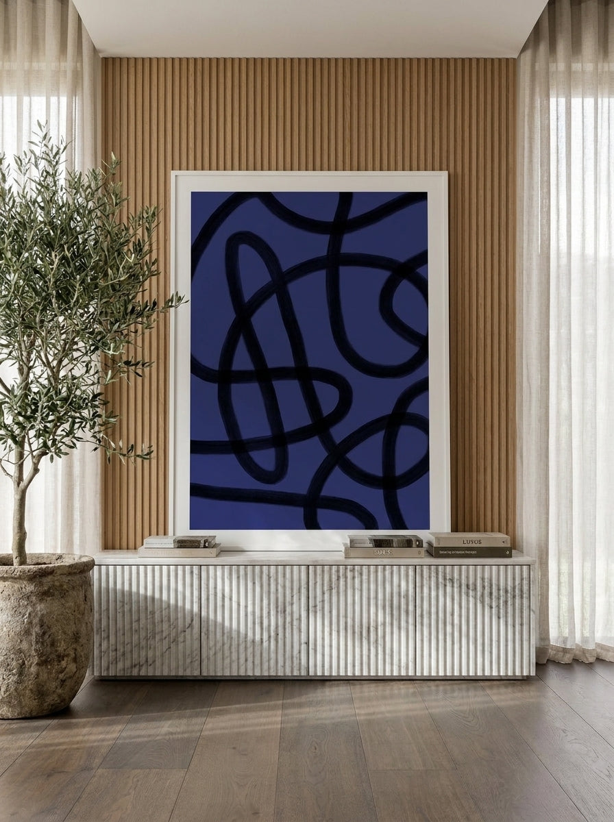 Modern wall art print standing on a sideboard in a luxe bedroom