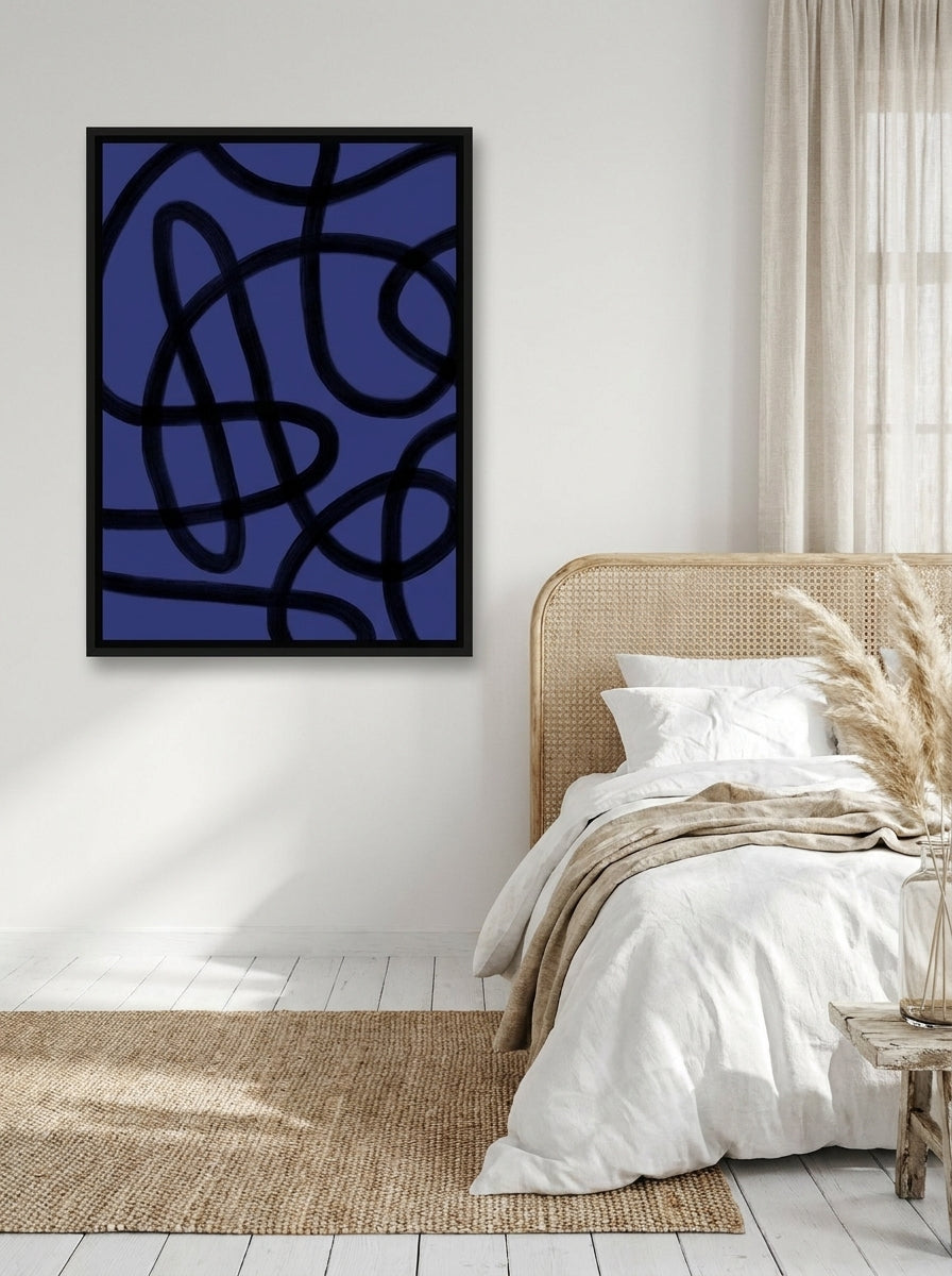 Canvas wall art with a black surround styled on the wall in a coastal bedroom