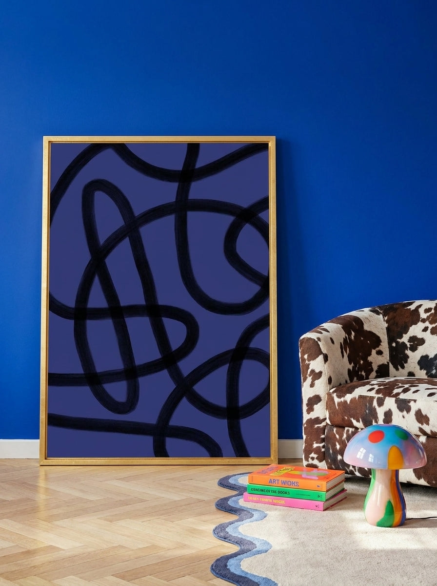 Canvas wall art with a gold leaf surround leaning against the wall in a colourful eclectic living room
