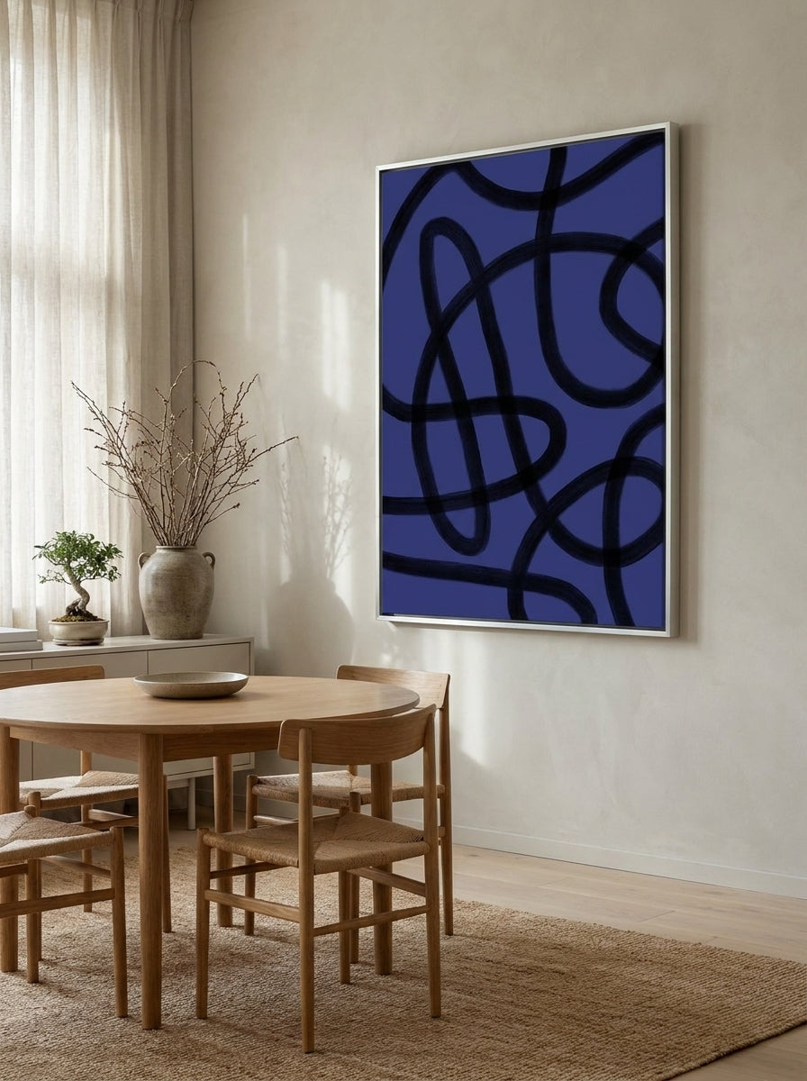 Oversized statement canvas wall art with a silver leaf surround styled on the wall in a warm Japandi dining room