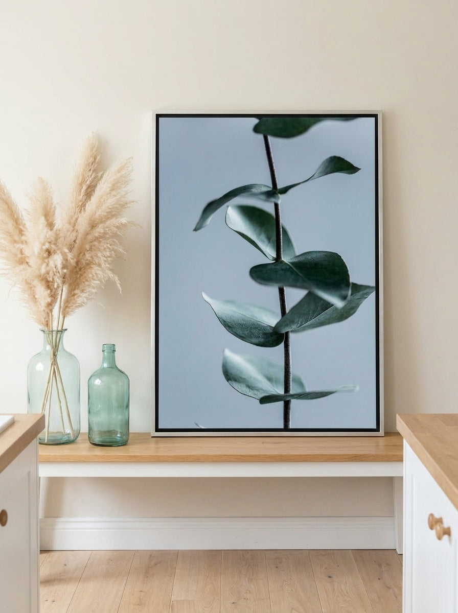 Canvas wall art with a silver leaf surround standing on a kitchen bench in a coastal kitchen