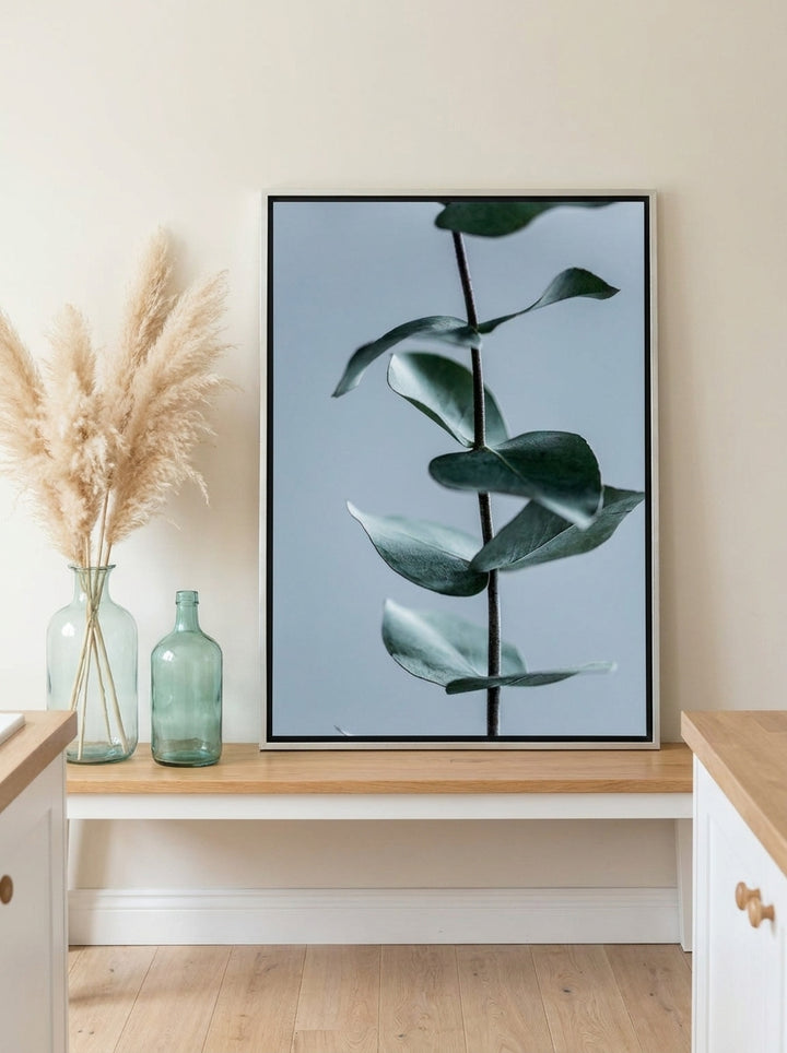 Canvas wall art with a silver leaf surround standing on a kitchen bench in a coastal kitchen