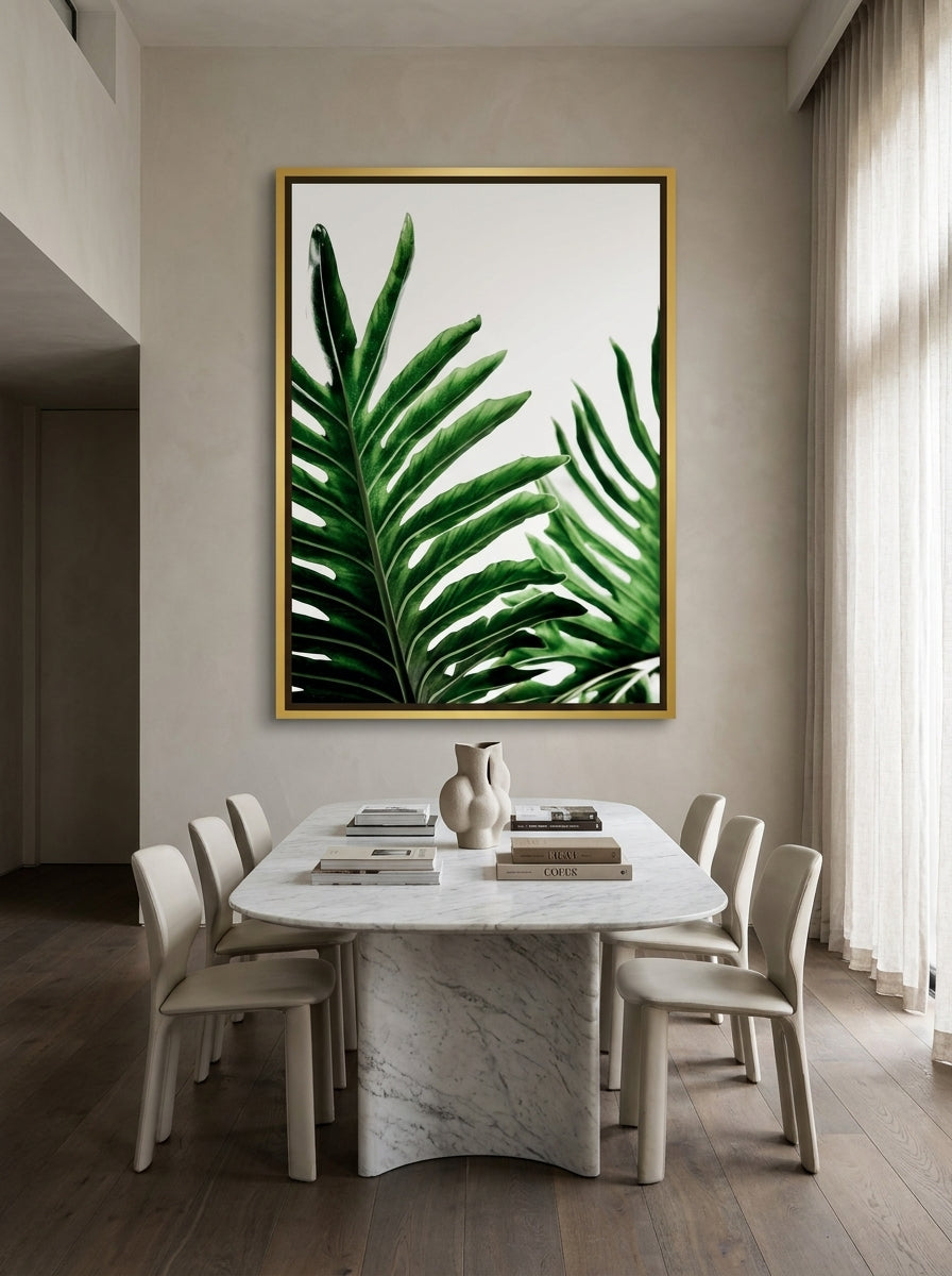 Oversized statement canvas wall art with a gold leaf surround styled on the wall in a luxe dining room