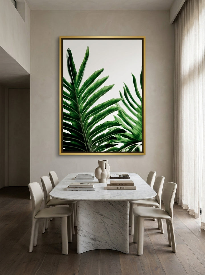 Oversized statement canvas wall art with a gold leaf surround styled on the wall in a luxe dining room