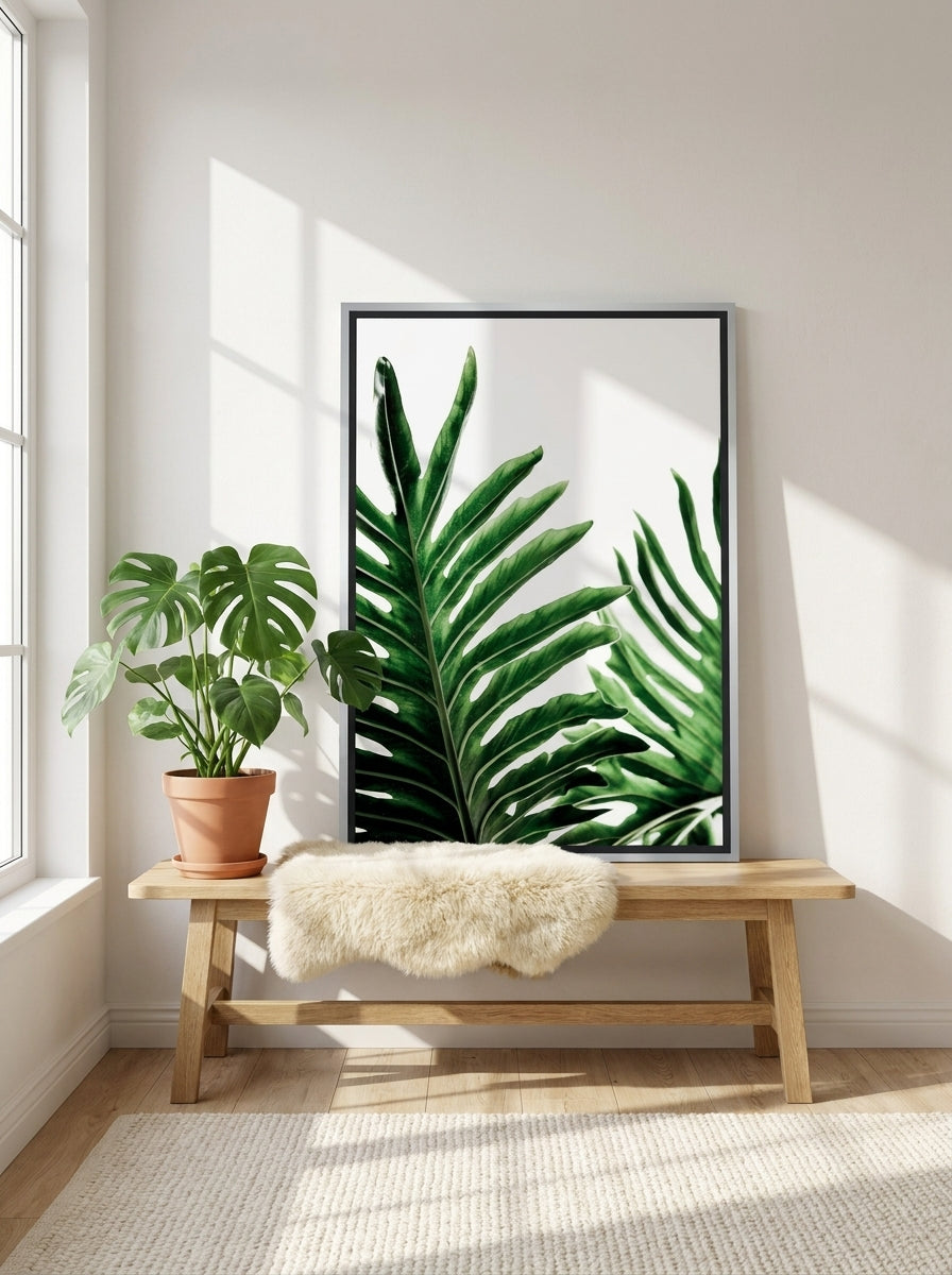 Canvas wall art with a silver leaf surround standing on a bench in a bright Scandinavian home office