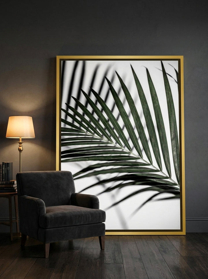 Oversized statement canvas wall art with a gold leaf surround leaning against the wall in a moody living room