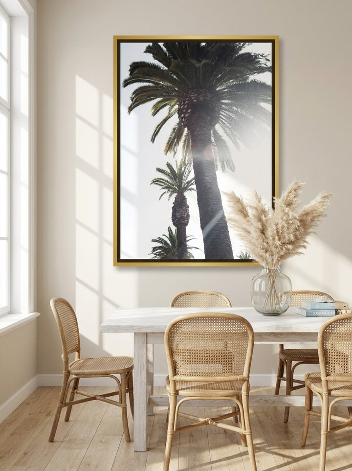 Canvas wall art with a gold leaf surround styled on the wall in a coastal dining room