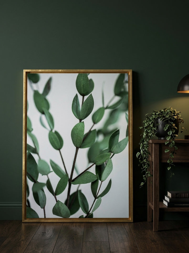 Canvas wall art with a gold leaf surround leaning against the wall in a moody kitchen