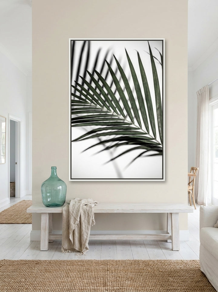 Oversized statement canvas wall art with a white surround styled on the wall in a coastal living room