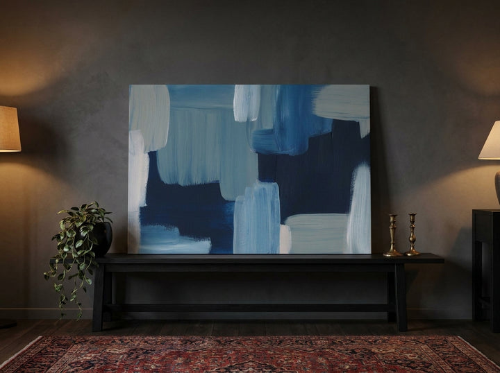 Stretched canvas wall art standing on a console in a moody bedroom