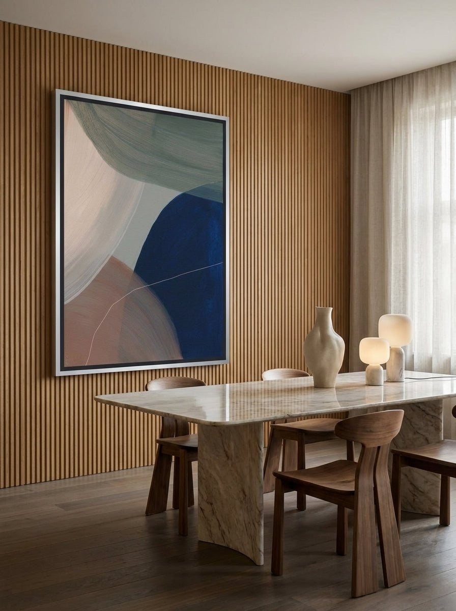 Oversized statement canvas wall art with a silver leaf surround styled on the wall in a luxe dining room