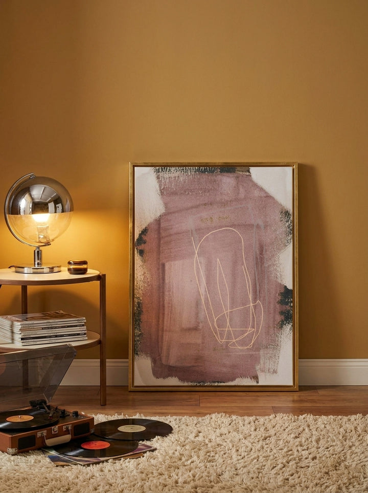 Canvas wall art with a gold leaf surround leaning against the wall in a retro 70s home office