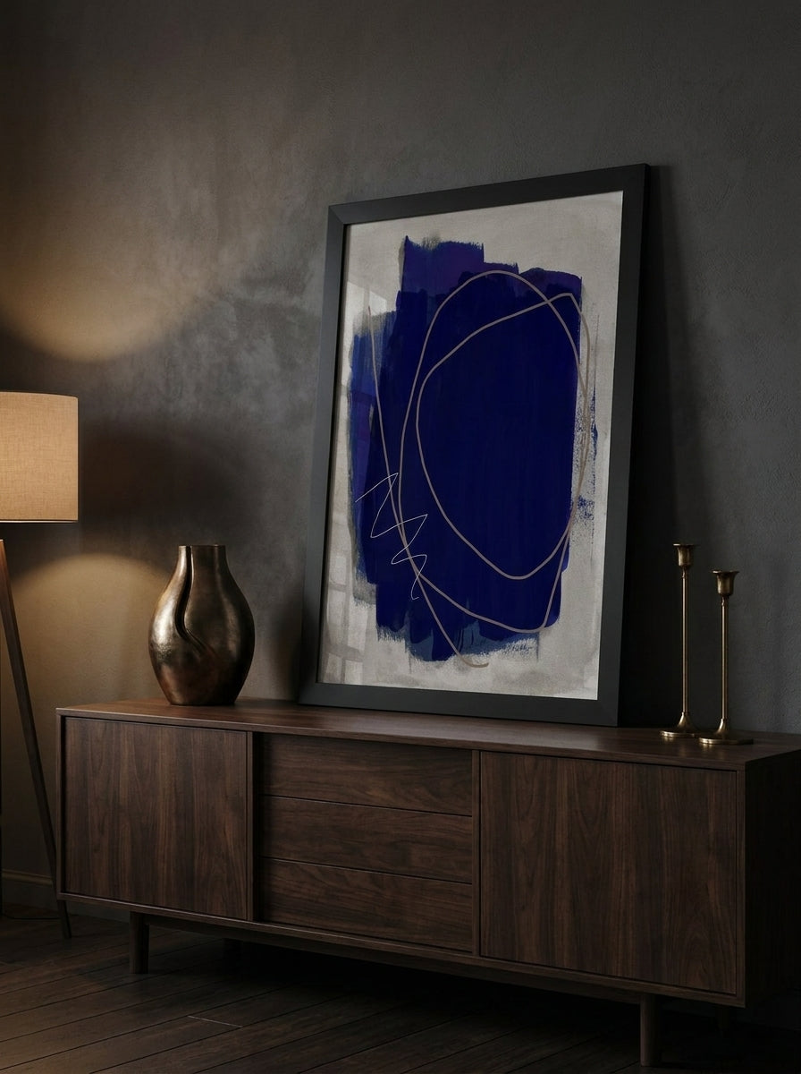 Modern wall art print standing on a sideboard in a moody home office