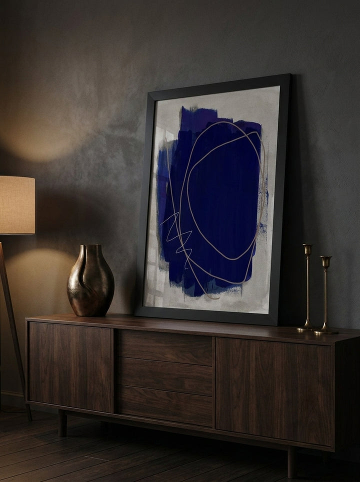 Modern wall art print standing on a sideboard in a moody home office