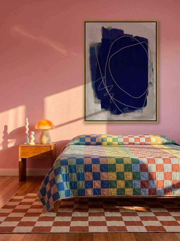 Canvas wall art with a natural timber surround styled on the wall in a colourful eclectic bedroom