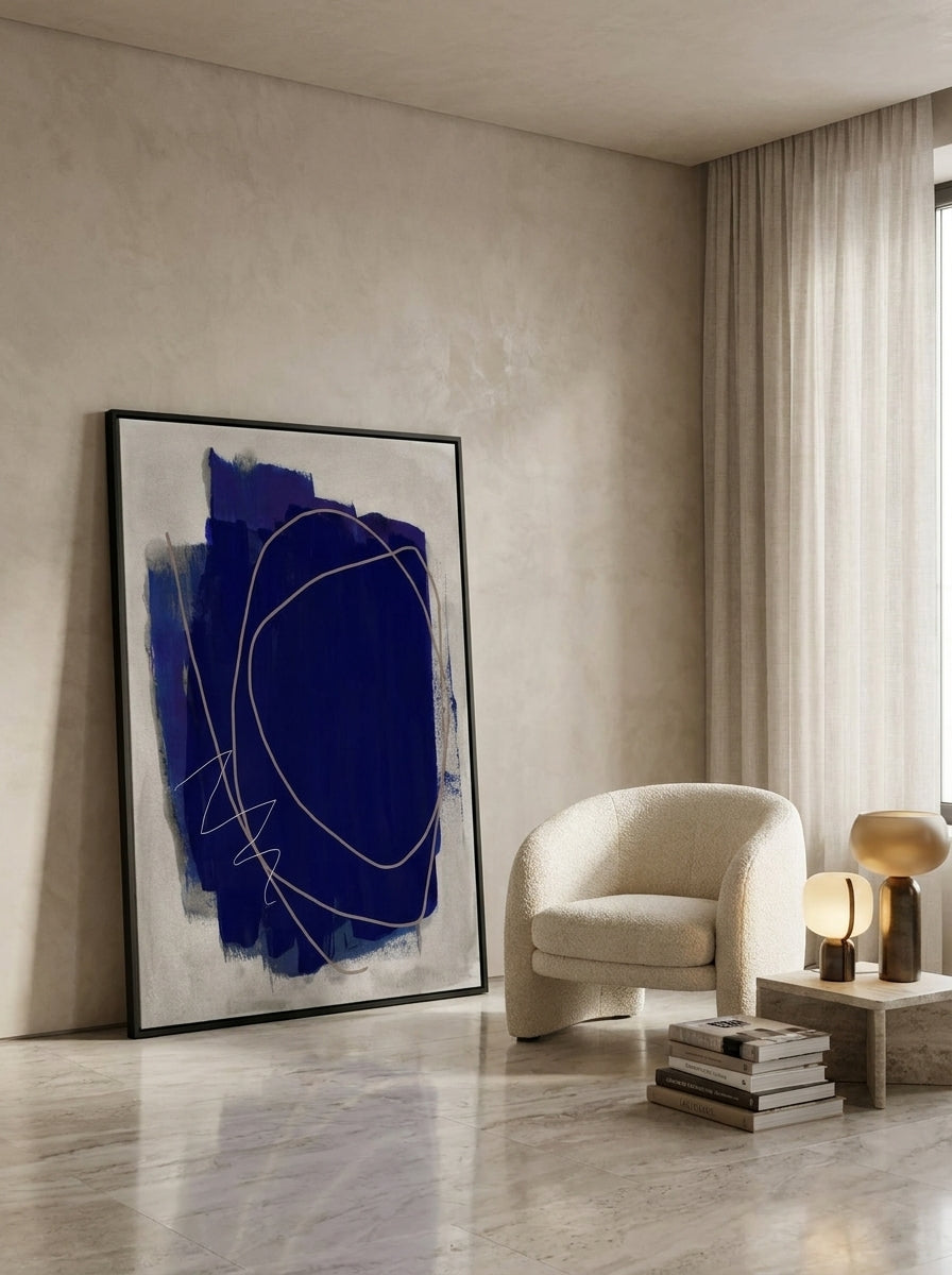 Oversized statement canvas wall art with a black surround leaning against the wall in a luxe dining room