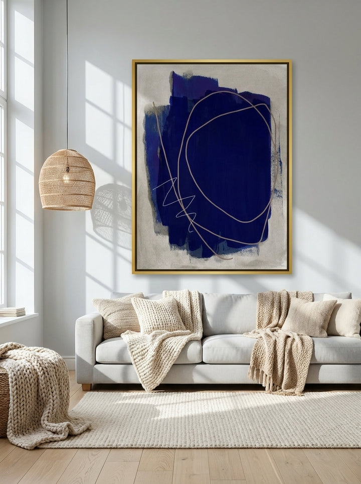 Oversized statement canvas wall art with a gold leaf surround styled on the wall in a bright Scandinavian living room