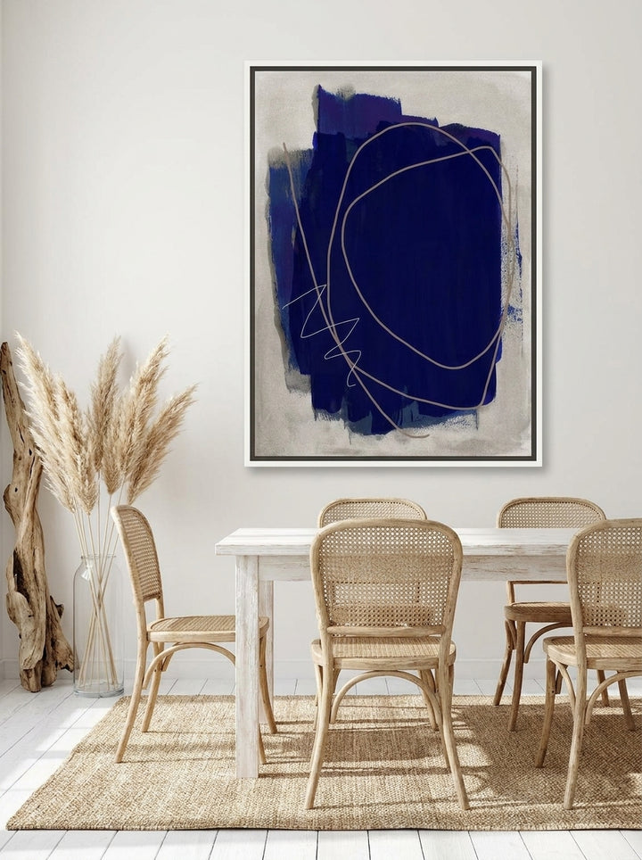 Canvas wall art with a white surround styled on the wall in a coastal dining room