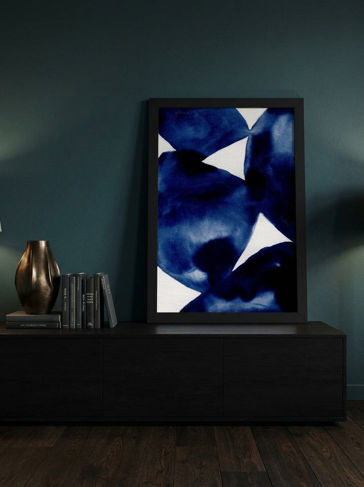 Modern wall art print standing on a console in a moody home office