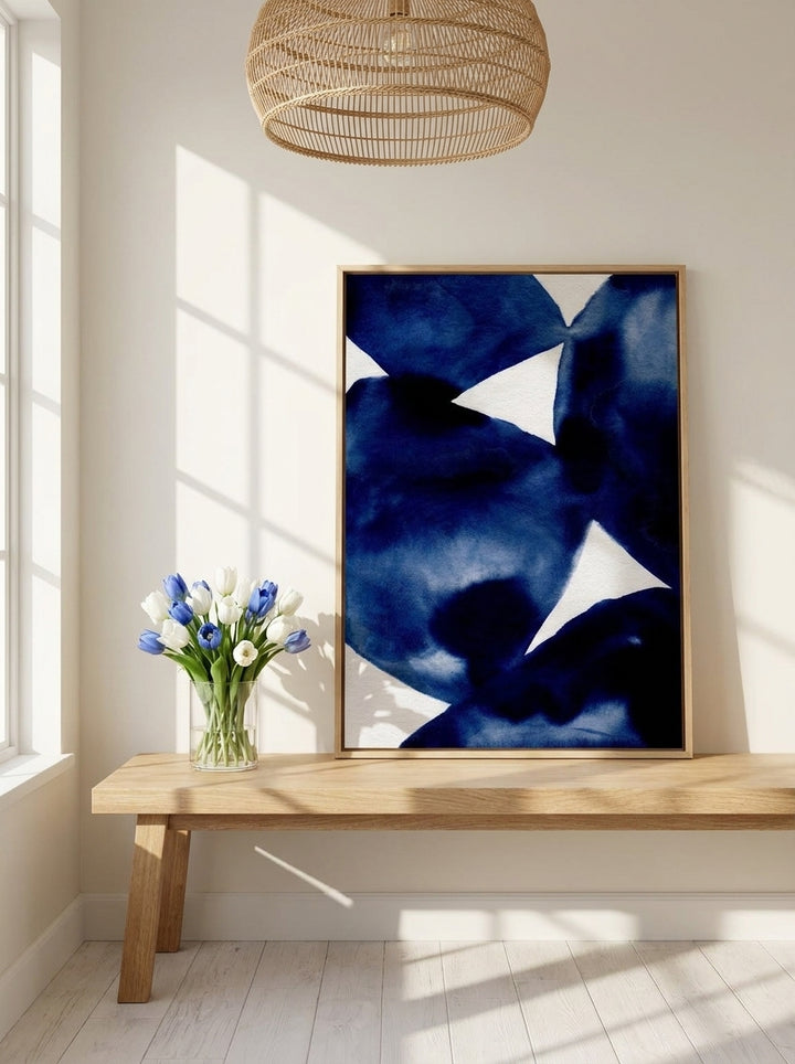 Canvas wall art with a natural timber surround standing on a bench in a bright Scandinavian bedroom