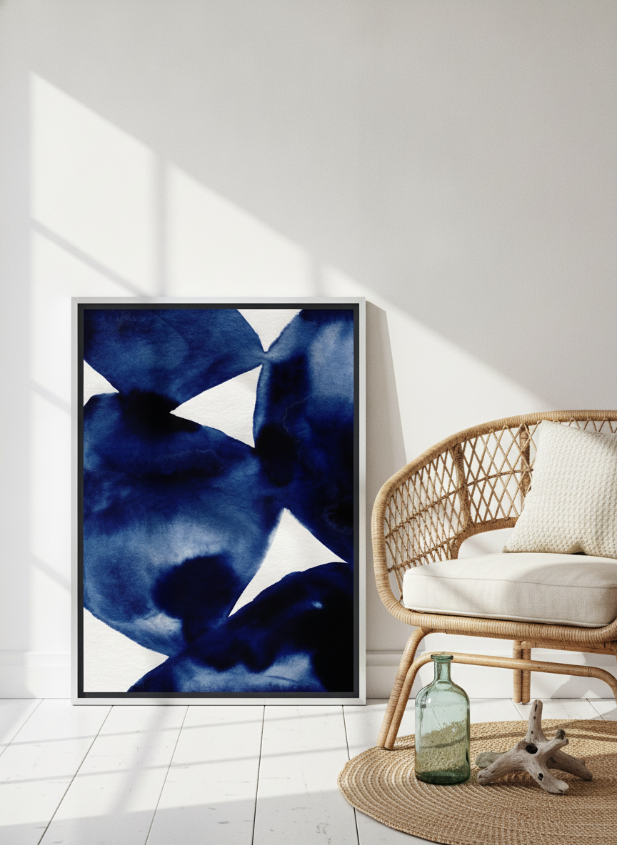 Canvas wall art with a silver leaf surround leaning against the wall in a coastal home office